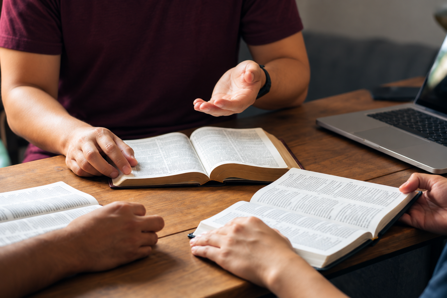 People discussing open books around a table